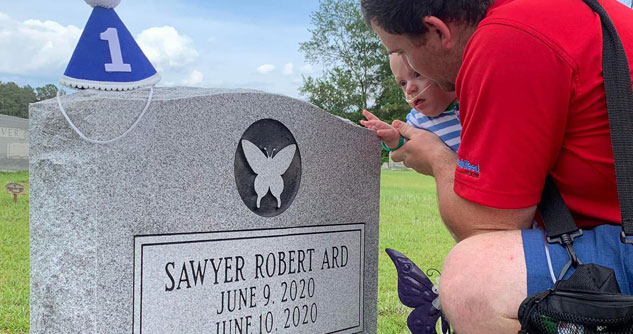 Tombstone with father and infant son nearby