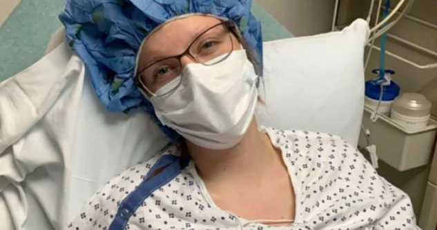 Woman in surgical mask and scrubs in hospital bed