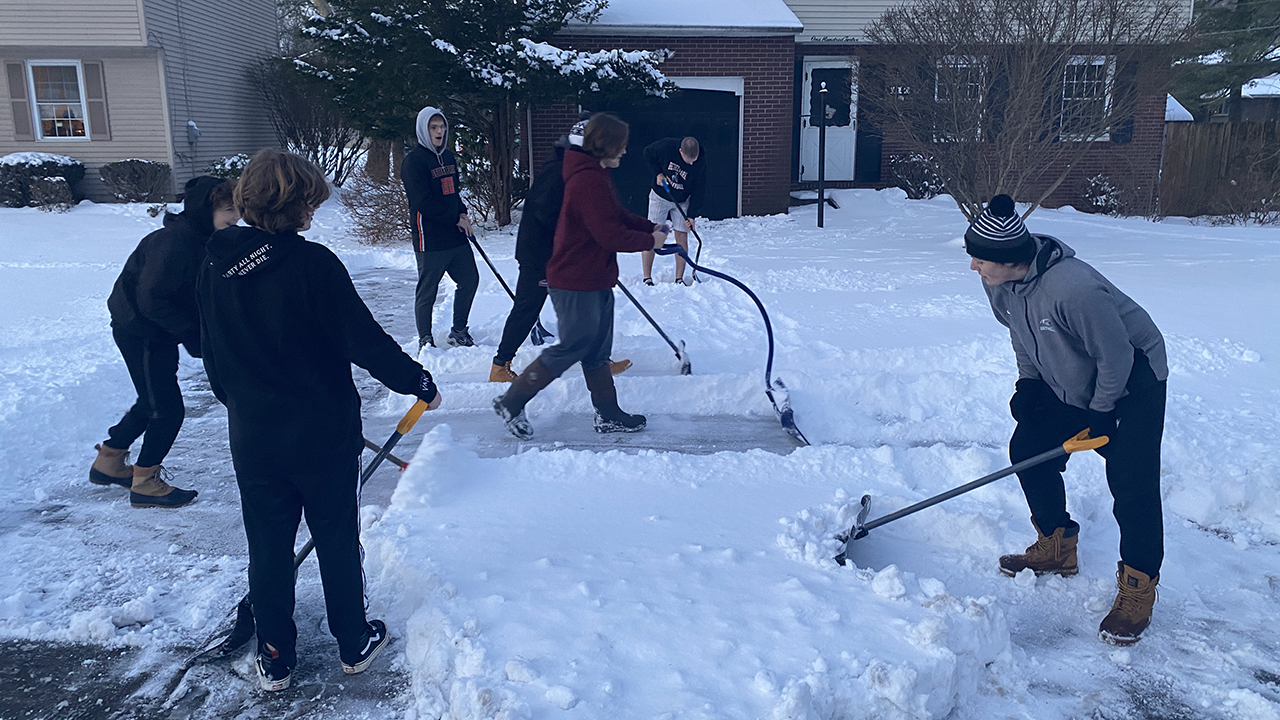 HIgh school kids shoveling snow