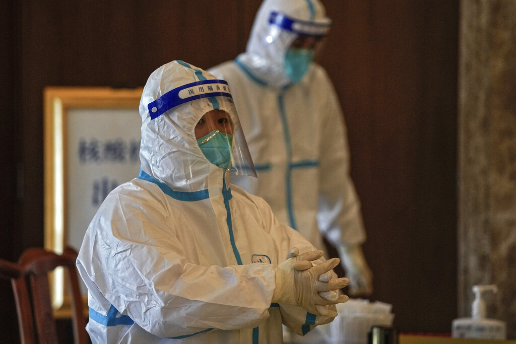 Medical workers wearing protective gear prepares swabs for people taking part in the Beijing Winter Olympics torch relay activities