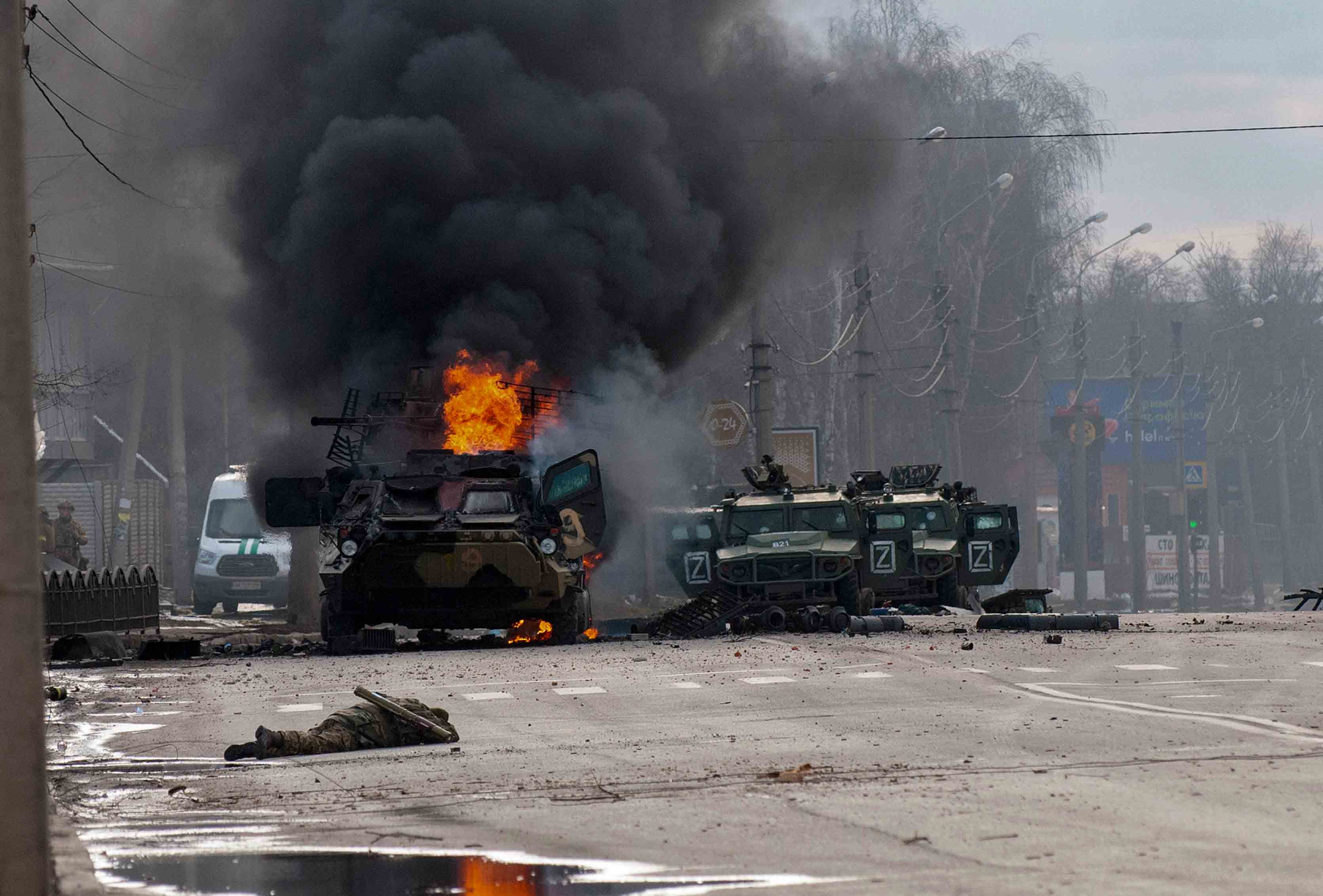 Um veículo blindado russo queima em meio a veículos utilitários leves danificados e abandonados após combate em Kharkiv, Ucrânia, domingo, 27 de fevereiro de 2022.