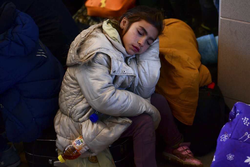 Ukrainian child rests after arriving in Hungary 