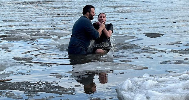 Man baptizing woman in icy Hudson River