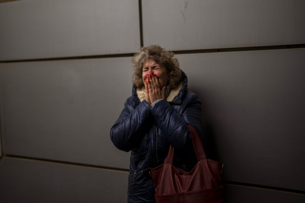Woman cries as she says goodbye to her daughter and grandson at Kyiv train station 