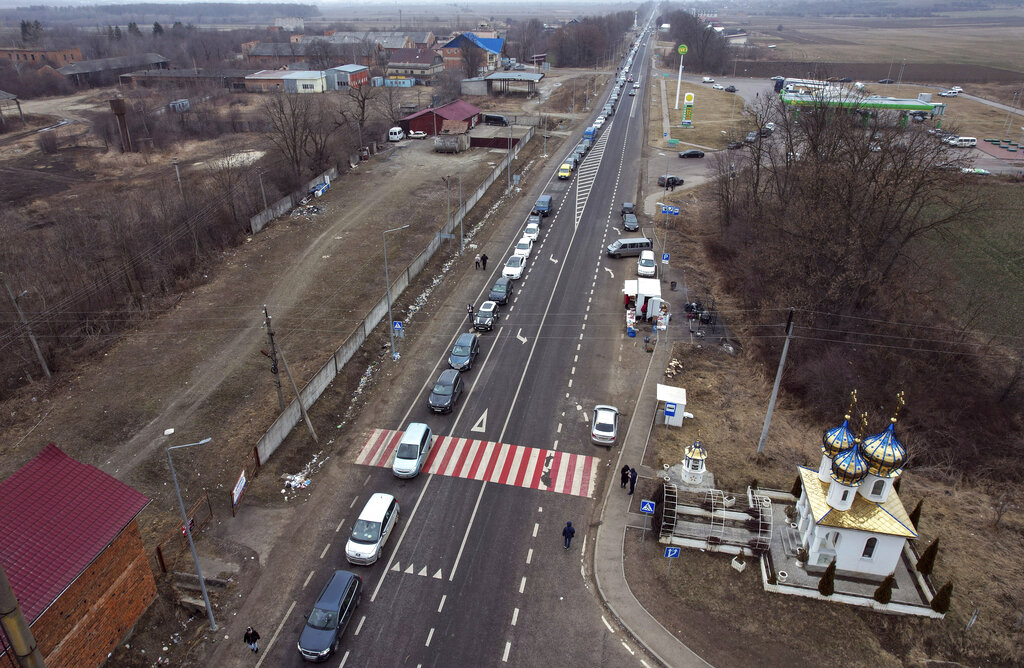 People fleeing from the conflict drive cars heading to the Ukrainian and Romania border near Cernivtsi, in Ukraine
