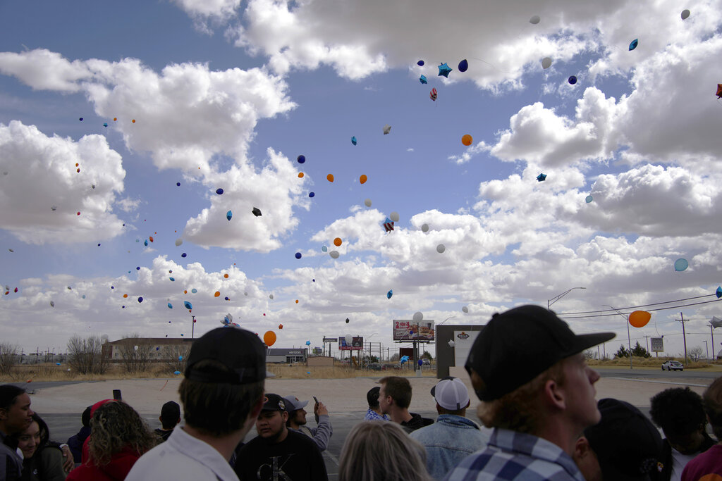 People watch after releasing balloons during a memorial