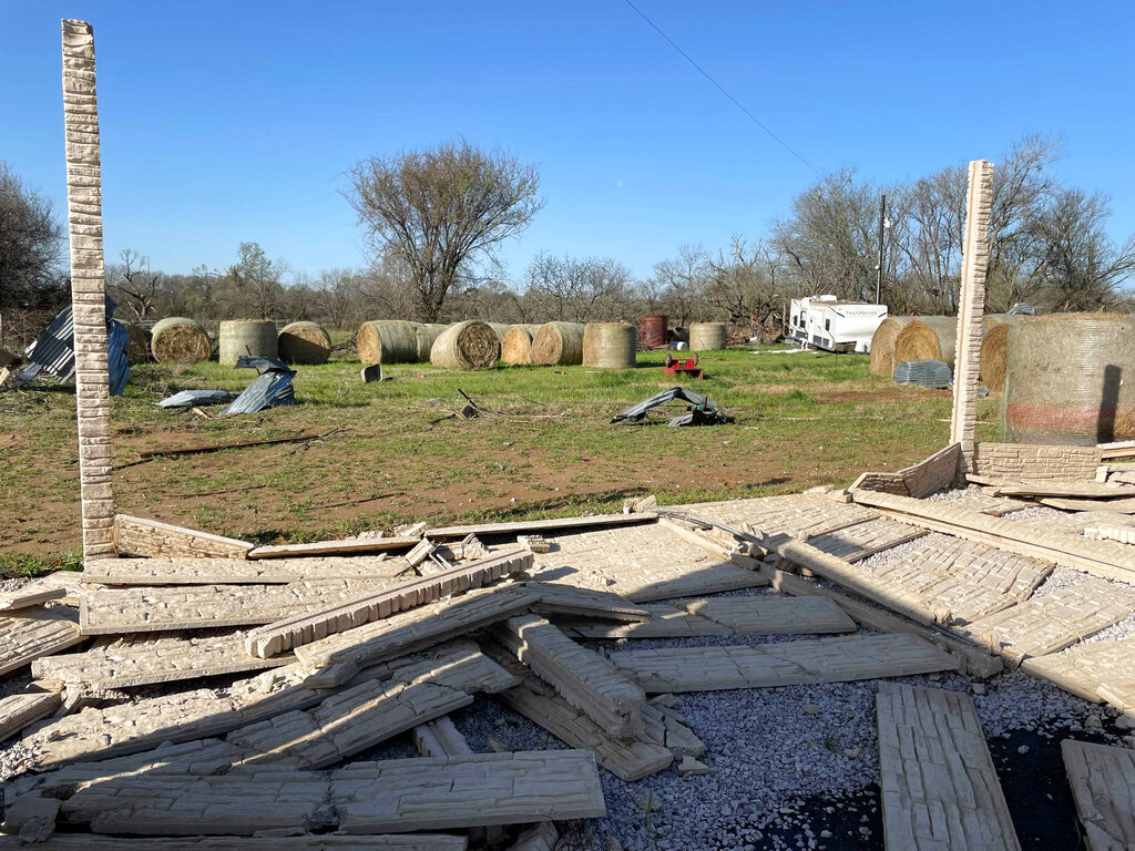 Debris lines the roads as crews and homeowners work to repair properties damaged by severe weather in Elgin, Texas