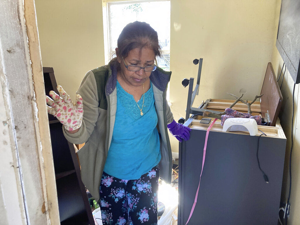 Dea Castellanos walks through her destroyed house in Arabi, La.