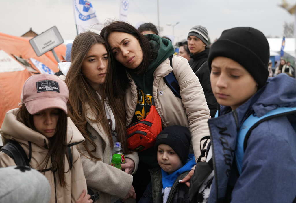 Refugees wait in a queue, after fleeing the war from neighboring Ukraine at the border crossing in Poland 