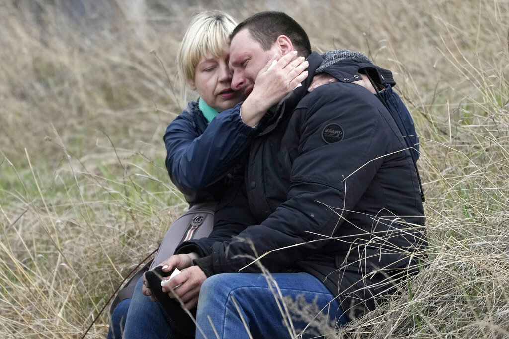 Relatives cry at the mass grave of civilians killed during the Russian occupation in Bucha, on the outskirts of Kyiv