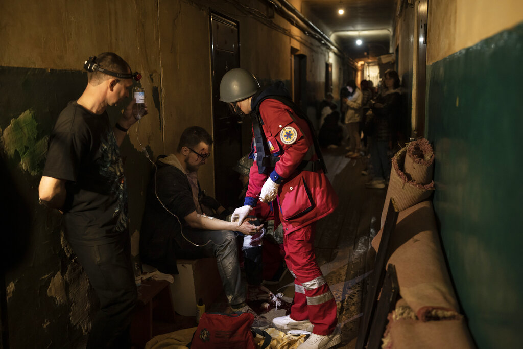 Vadim Krikun is treated in the hallway of his apartment building after a Russian attack in Kharkiv, Ukraine