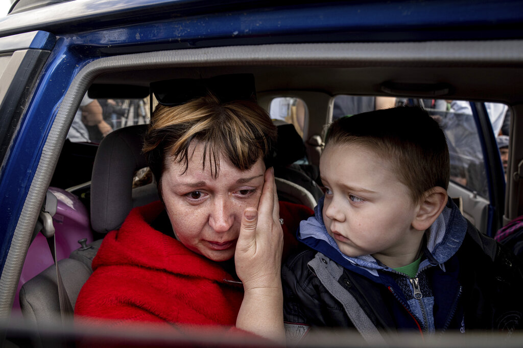 Natalia Pototska cries as her grandson Matviy looks on in a car at a center for displaced people in Zaporizhzhia, Ukraine