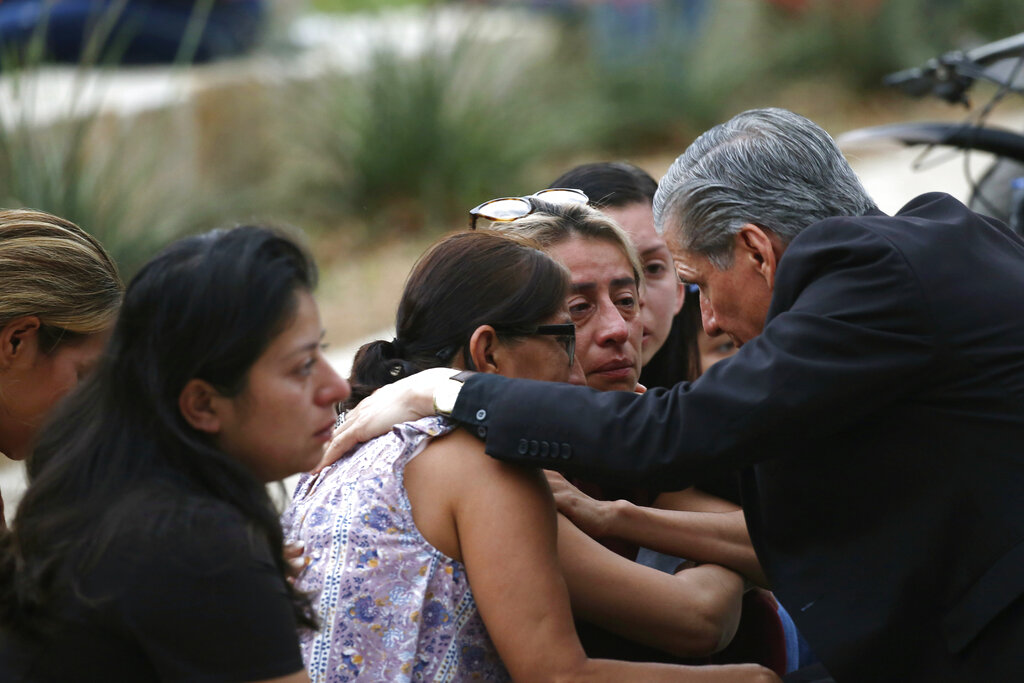 The Archbishop of San Antonio, Gustavo Garcia Seller, comforts families 