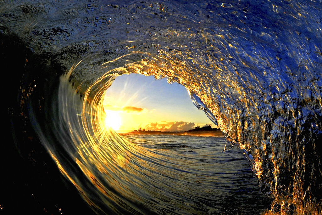 In this undated photo entitled "Sun Curl," the rising sun is framed by a breaking wave on the North Shore of Oahu near Haleiwa, Hawaii.