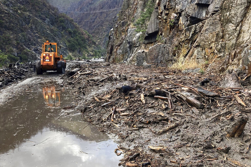 Crews work to clear a multiple slides along Highway 70 in the Feather River Canyon near Belden, Calif.
