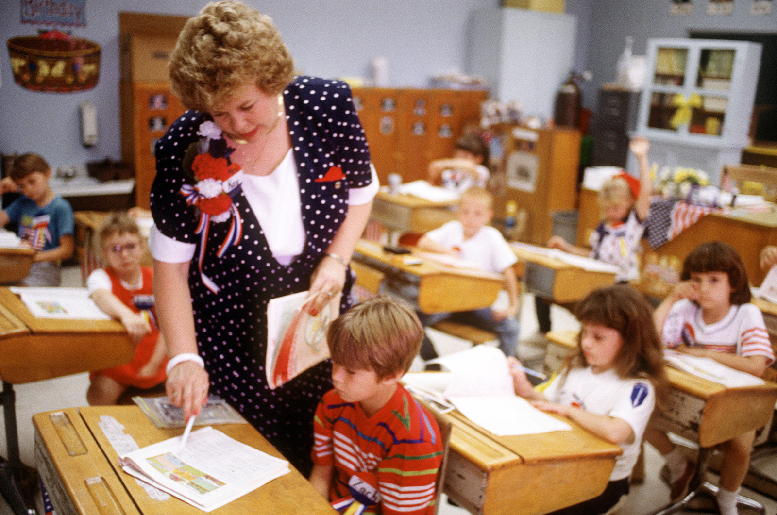 Teacher helping child in classroom
