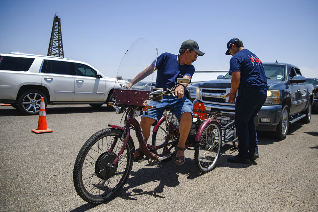 Odessa Fire Rescue cadet Benjamin Magallanez, right, loads a cart with a box of emergency drinking water for an Odessa resident