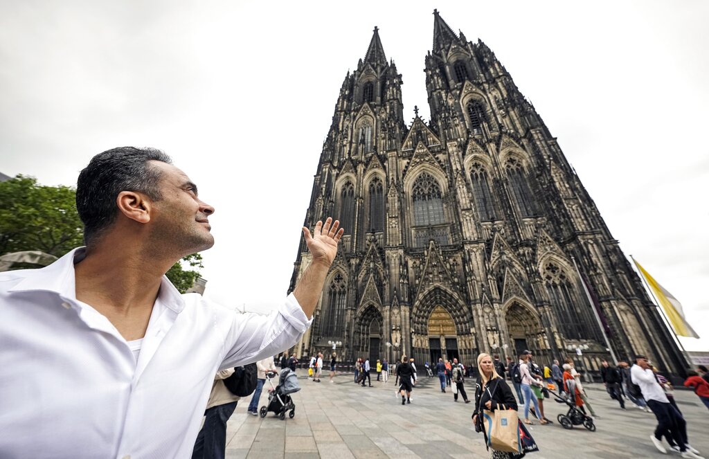 Fadel Alkhudr from Syria poses near the word heritage Cologne Cathedral in Cologne, Germany