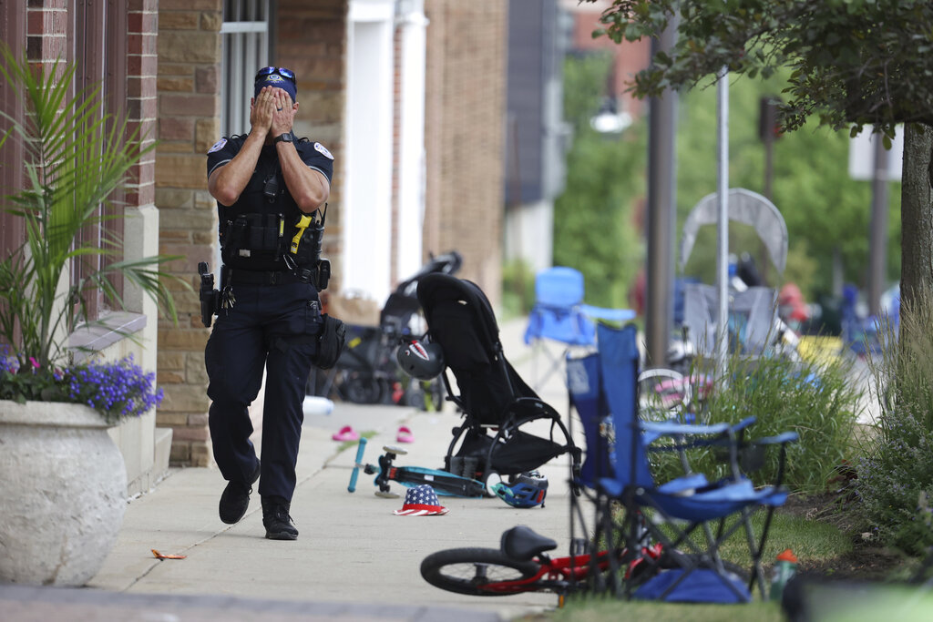 A police officer walks down Central Ave in Highland Park, Ill. after a shooter fired on the northern suburb's Fourth of July parade.