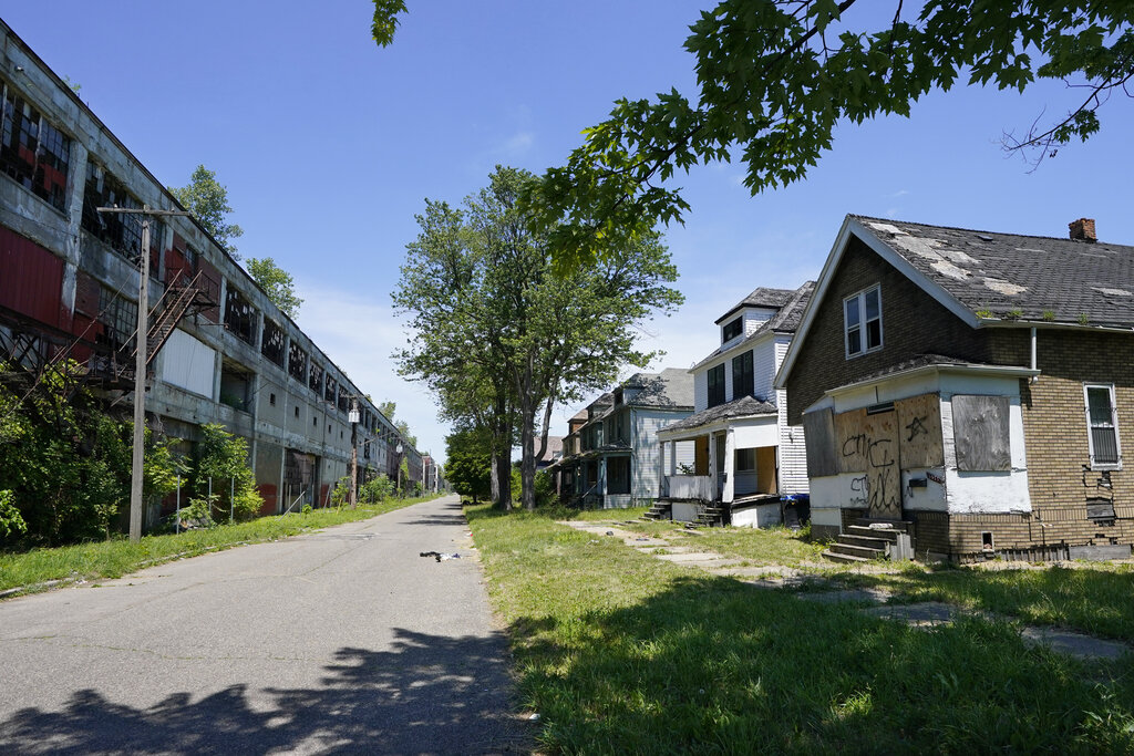 Exterior of the Packard Plant, left, next to boarded up houses on Detroit's east side