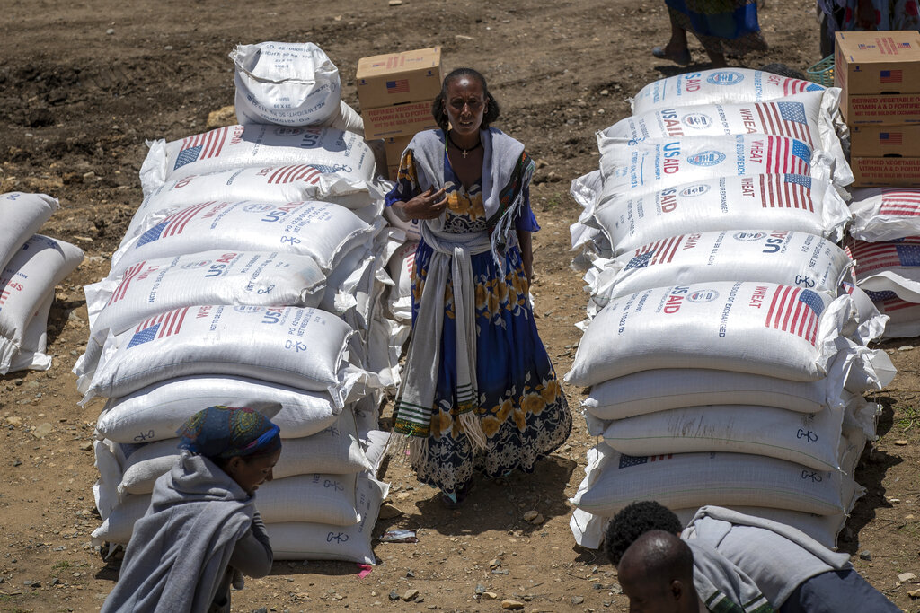 An Ethiopian woman stands by sacks of wheat to be distributed by the Relief Society of Tigray in the town of Agula, in the Tigray region of northern Ethiopia Saturday, May 8, 2021. World hunger rose in 2021 with around 2.3 billion people facing moderate or severe difficulty obtaining food -- and that was before the Ukraine war which has sparked increases in the cost of grain, fertilizer and energy, according to a U.N. report launched Wednesday, July 6, 2022.