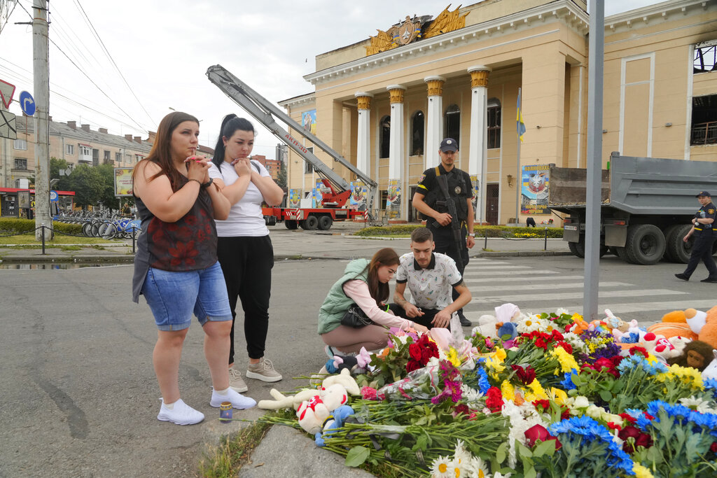 People pray and lay flowers at the site of a Russian shelling on Thursday, in Vinnytsia, Ukraine