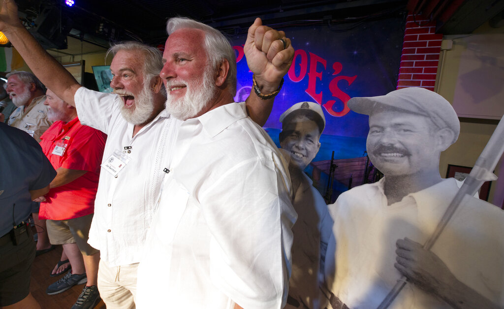 Joe Swinford, left, and Steve Usuina, right, have fun while standing next to a photographic cutout of Ernest Hemingway