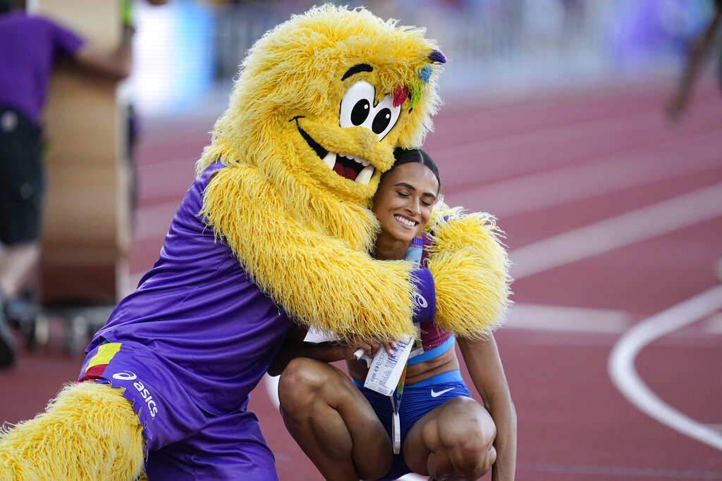 Gold medalist Sydney McLaughlin is embraced after winning the final of the women