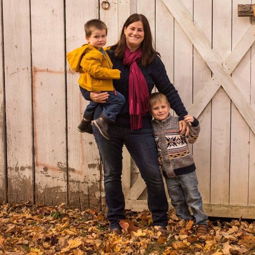Woman with two little boys near a barn door