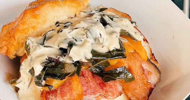 Biscuit sandwich with cream, bacon, collard greens and cheese