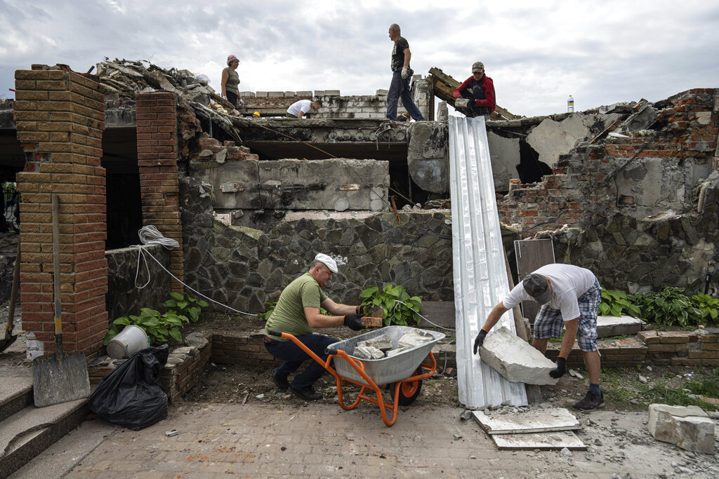 Volunteers clear rubble on the ground floor of Zhanna and Serhiy Dynaeva