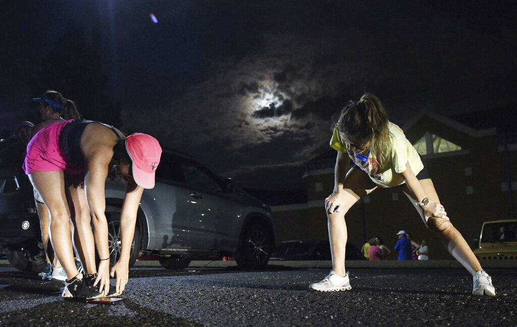 From left, Lauren Pickett and Molly Connolly stretch before taking part in "Finish Eliza