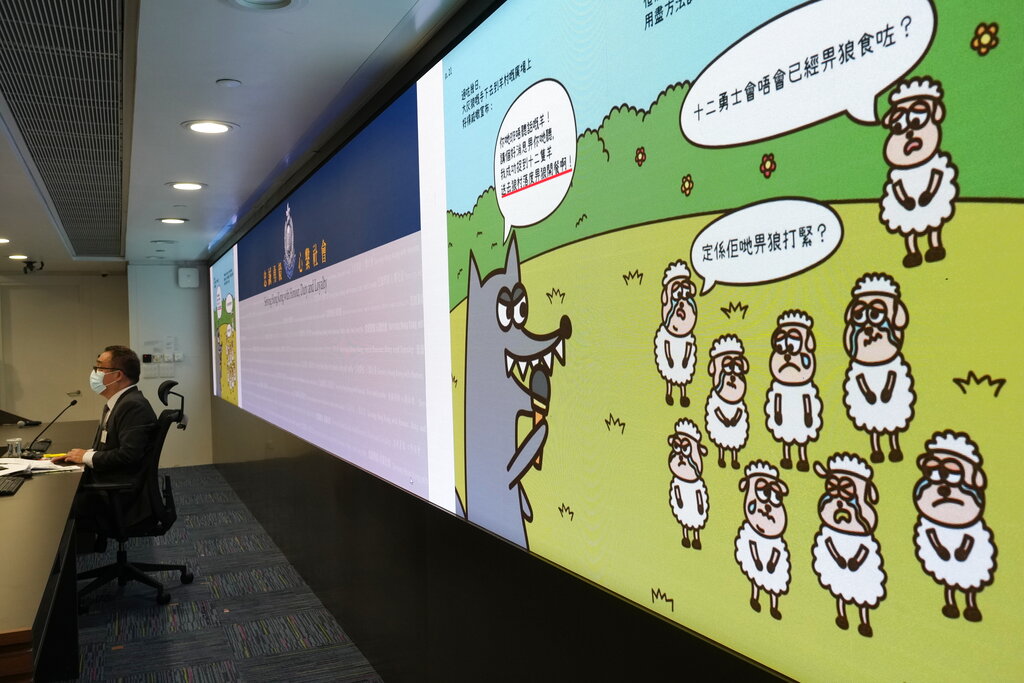 Li Kwai-wah, left, senior superintendent of Police National Security Department speaks in front of a screen showing evidence of three children