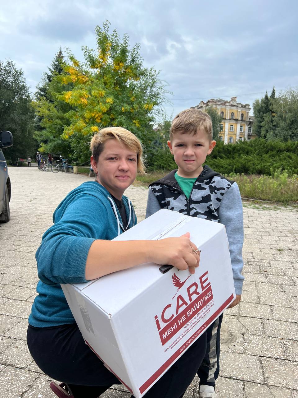 A mom and son in Izyum holding an iCare food box.
