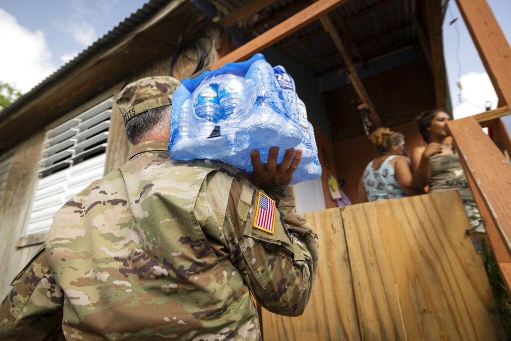 A National Guardsman delivers water to the residents of Punta Diamante in Ponce, Puerto Rico