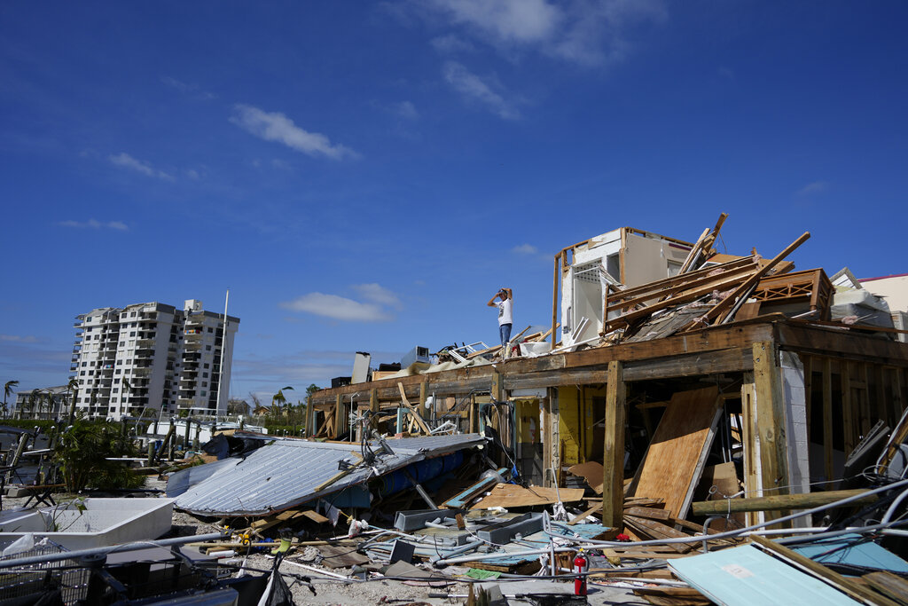 Robert Leisure surveys the wreckage of his business, Getaway Marina, which was destroyed during the passage of Hurricane Ian, in Fort Myers Beach, Fla.