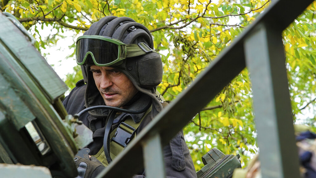 A Ukrainian serviceman sits on a T-80 tank that they claimed had been captured from the Russian army