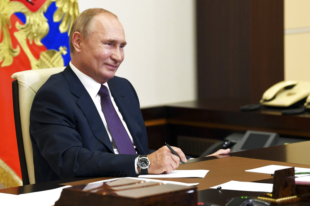 Russian President Vladimir Putin smiles as he attends a meeting via video conference at the Novo-Ogaryovo residence outside Moscow, Russia