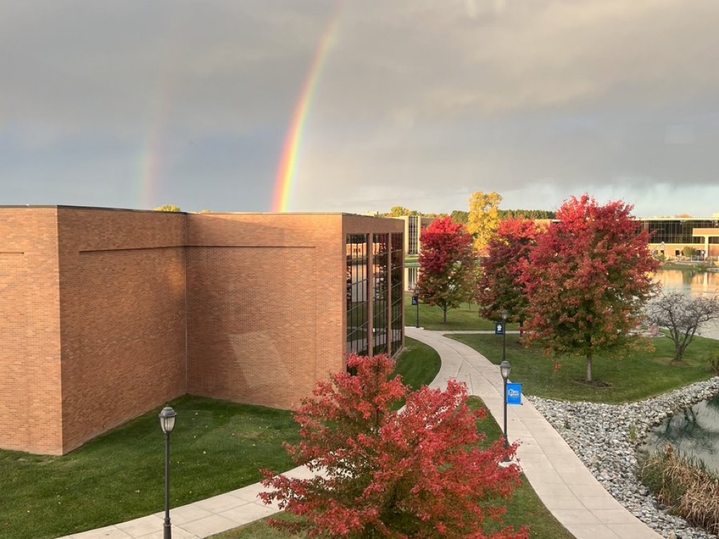 Rainbow fills the sky over part of Centennial Library, Cedar Lake, and the Stevens Student Center 