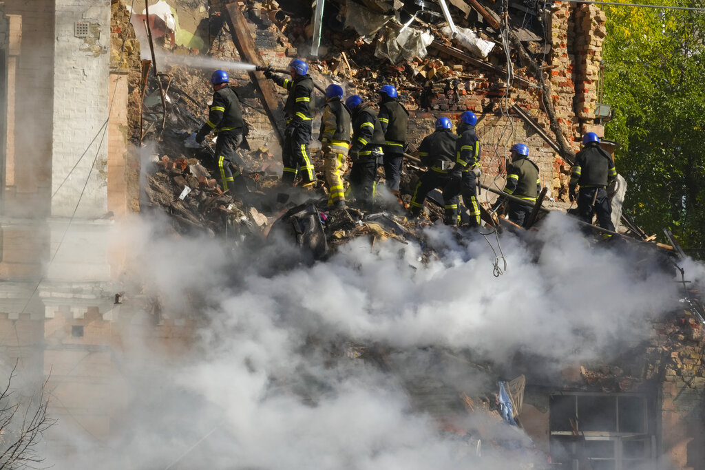 Firefighters try to extinguish a fire after a drone fired at buildings in Kyiv, Ukraine