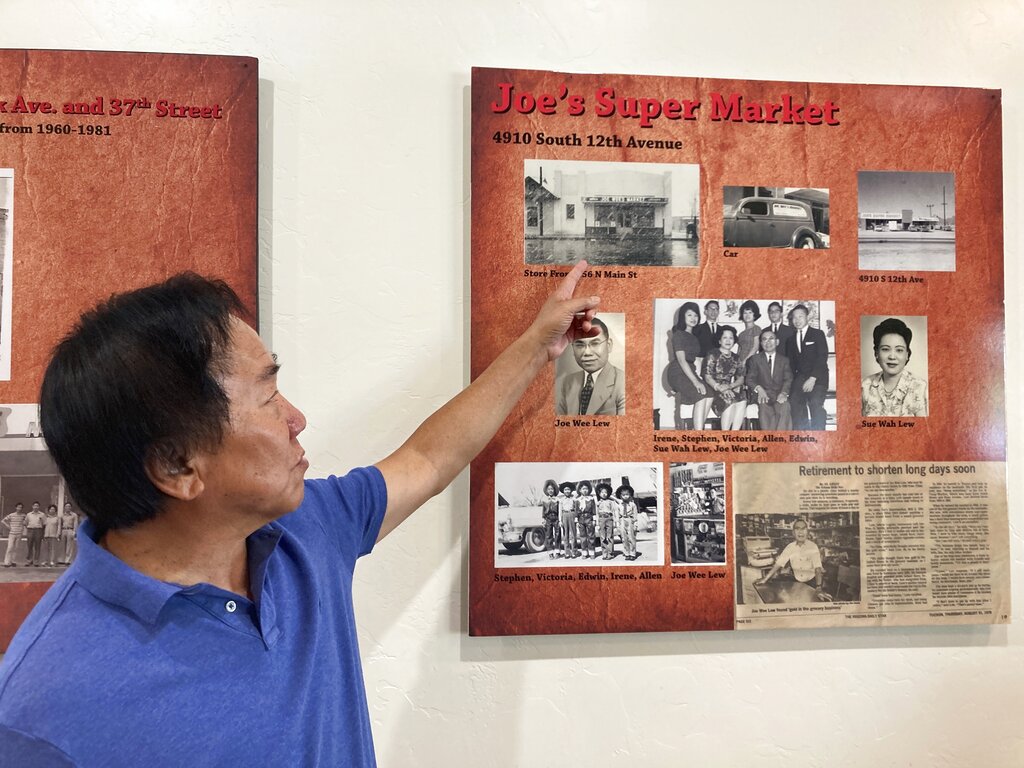 Allen Lew points to a display board at the Tucson Chinese Cultural Center in Tucson, highlighting his father