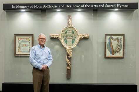 Bill Bolthouse stands in front of the new art display in Cedarville University