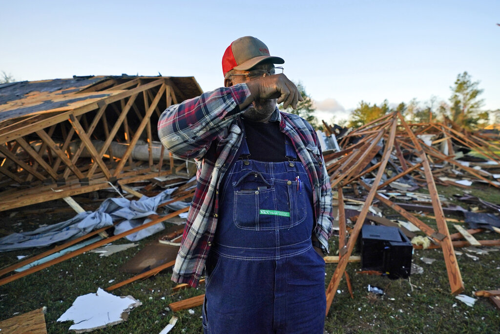 Fred Davis wipes his face as he describes building his home and the damage after a tornado hit in Powderly, Texas