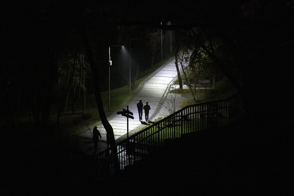 People walk in a park during a blackout in Kyiv, Ukraine