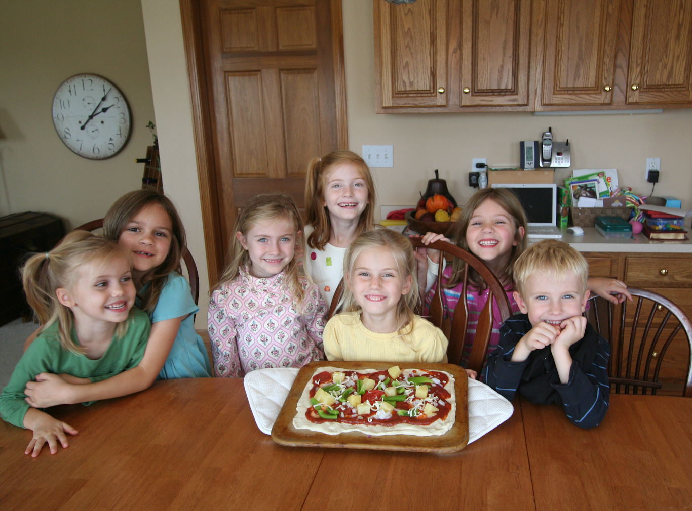 (around 2008) Sarah-Kate, Anna, and Simon make pineapple pizza with friends.