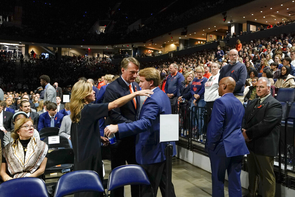 Virginia Gov. Glenn Youngkin and his wife Suzanne Youngkin greet a University of Virginia football player before a memorial service 