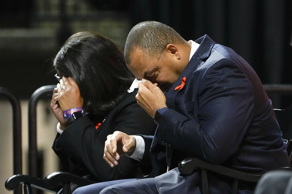 University of Virginia Athletic Director Carla Williams, left, and football coach Tony Elliott wipe tears from their eyes during a memorial service 