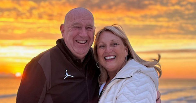 Smiling man and woman with sunset in the background
