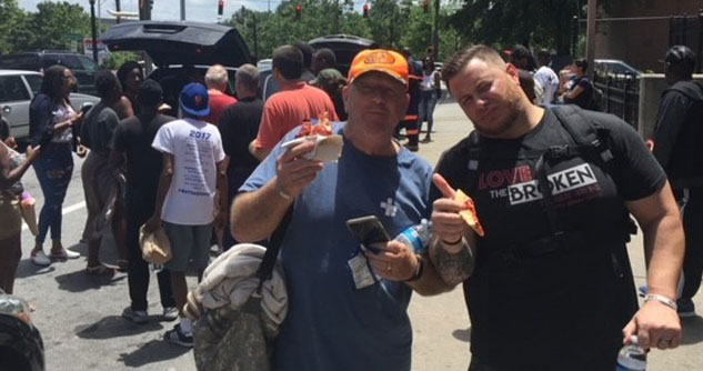 Two men holding food on the streets 