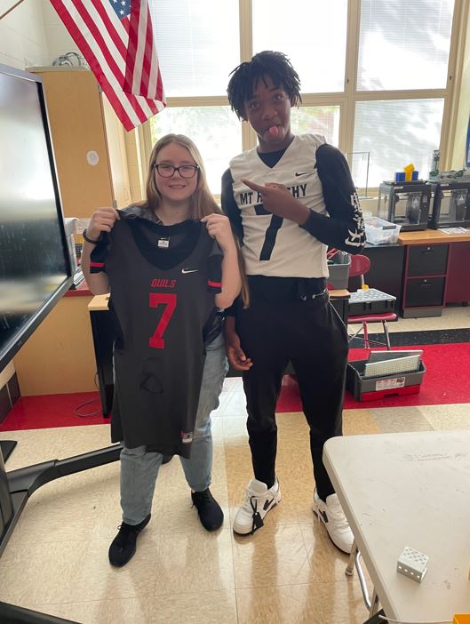 Student giving Mt Healthy High School staff member their jersey to wear